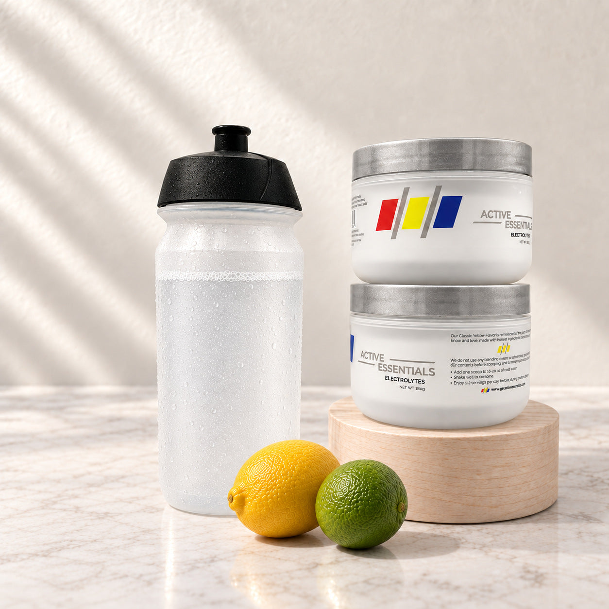 Two stacked Active Essentials jars with a chilled water bottle, lemon and lime